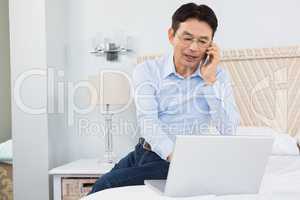 Man on a phone call using laptop