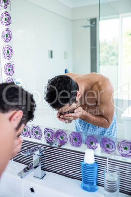 Handsome man washing his face