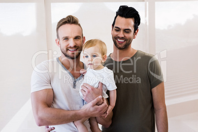 Smiling gay couple with child