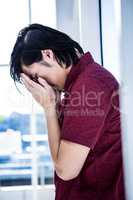 Worried creative businessman leaning on wall