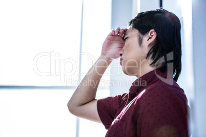 Worried creative businessman leaning on wall