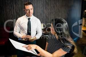 Woman ordering to waiter from the menu