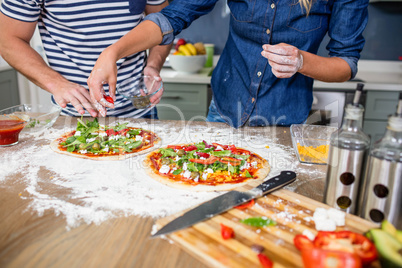 Smiling couple preparing pizza