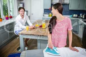 Brunette ironing and talking to her boyfriend