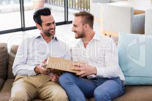 Smiling man offering gift to his boyfriend