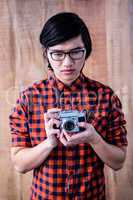 Thoughtful hipster holding an old camera