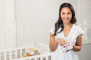 Smiling brunette holding baby shoes