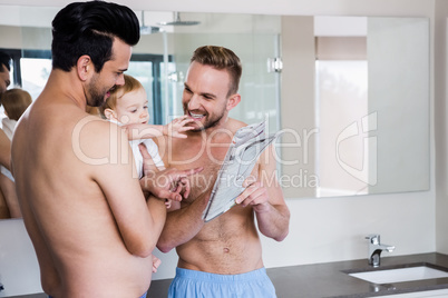 Smiling gay couple with child