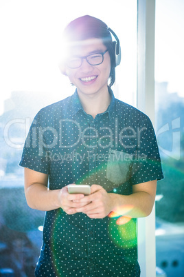 Smiling asian businessman listening to music