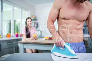 Shirtless man ironing