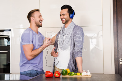 Smiling gay couple listening to music