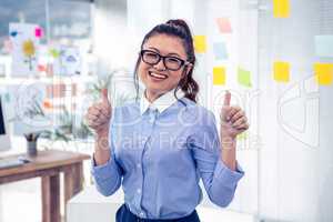 Smiling Asian businesswoman showing thumbs up