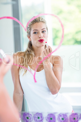 Woman with lipstick looking in the mirror