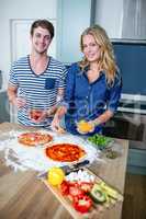 Smiling couple preparing pizza