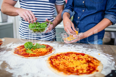 Smiling couple preparing pizza