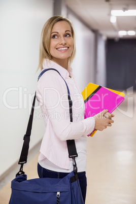 Happy female student walking in the hallway