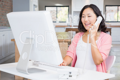 Smiling pregnant woman in a call on land line