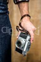 Hipster man holding digital camera