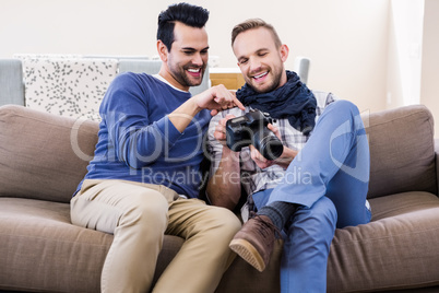 Gay couple watching pictures on the couch