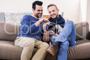 Gay couple watching pictures on the couch