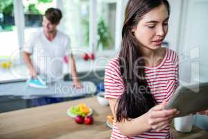 Brunette using tablet in kitchen