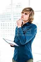 Thoughtful hipster businessman using tablet