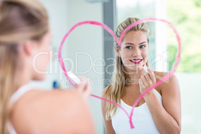 Woman with lipstick looking in the mirror