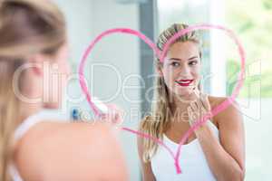 Woman with lipstick looking in the mirror