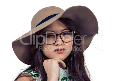 Asian woman with hand on chin wearing hat