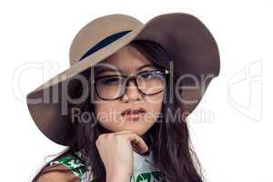 Asian woman with hand on chin wearing hat