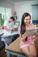 Brunette using tablet in kitchen