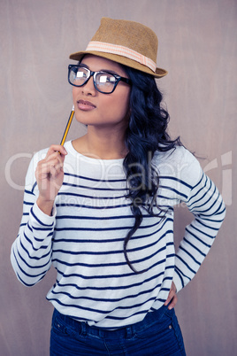 Attractive Asian woman with hat holding pencil