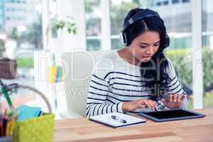 Smiling Asian woman with headphones using tablet