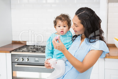 Happy brunette feeding her baby