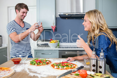 Smiling couple preparing pizza