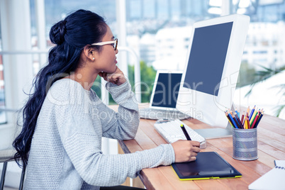 Smiling Asian woman using digital board and computer