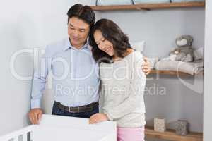 Happy couple looking in crib