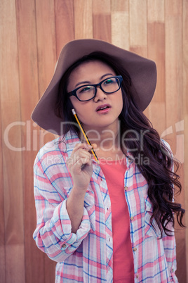 Asian woman with hat holding pencil