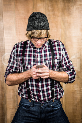 Focused blond hipster holding smartphone