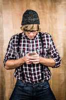 Focused blond hipster holding smartphone