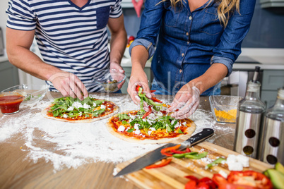 Smiling couple preparing pizza