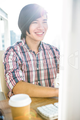 Smiling hipster businessman using computer