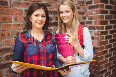 Smiling students with binder looking at camera