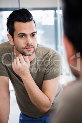 Handsome man looking in mirror