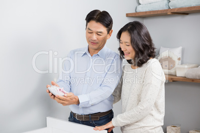 Happy couple holding baby shoes