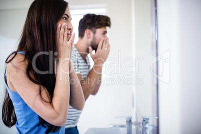 Young couple looking themselves in the mirror