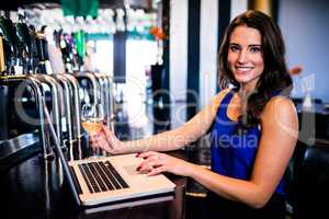 Portrait of Woman using laptop and having a drink
