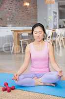 Calm woman doing yoga on mat