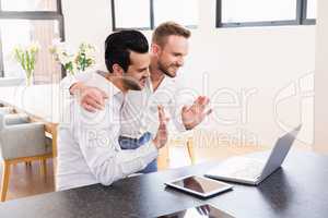 Smiling gay couple doing video chat