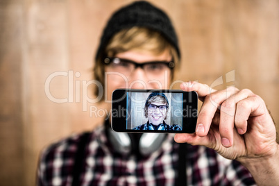 Smiling blond hipster taking selfie